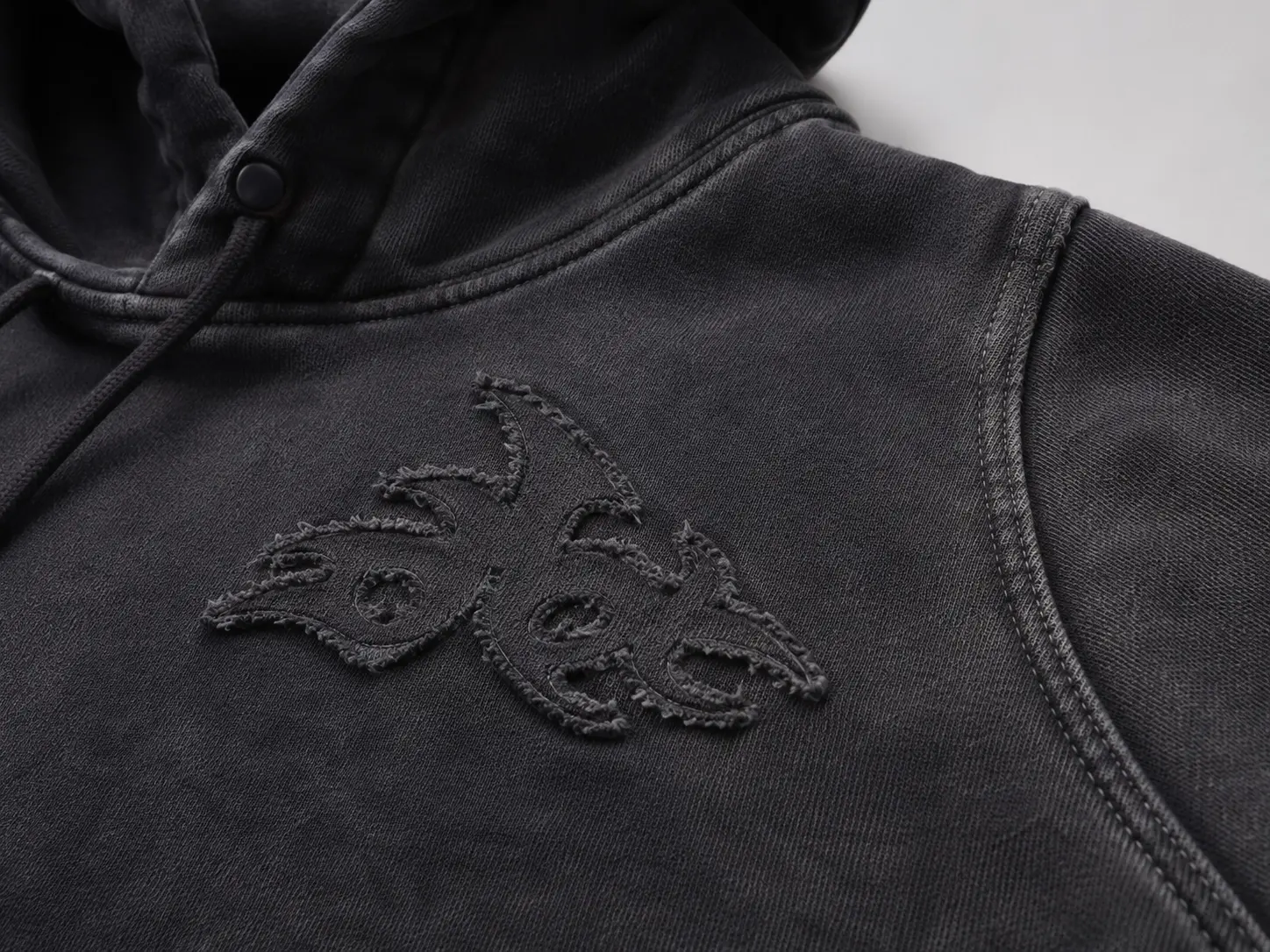 Applique detail on washed hoodie with textured fabric surface